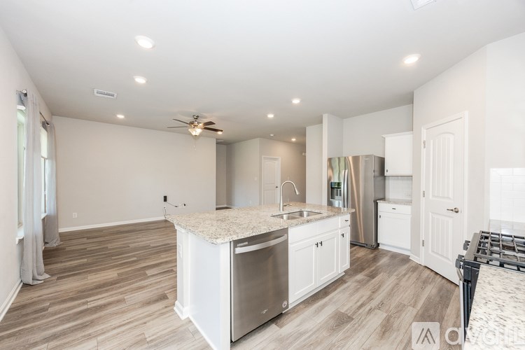 A kitchen with a white island and stainless steel appliances.