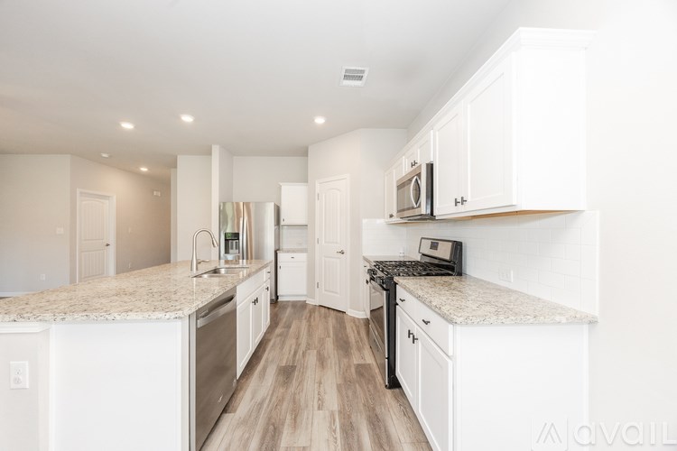 A kitchen with white cabinets and a granite countertop.