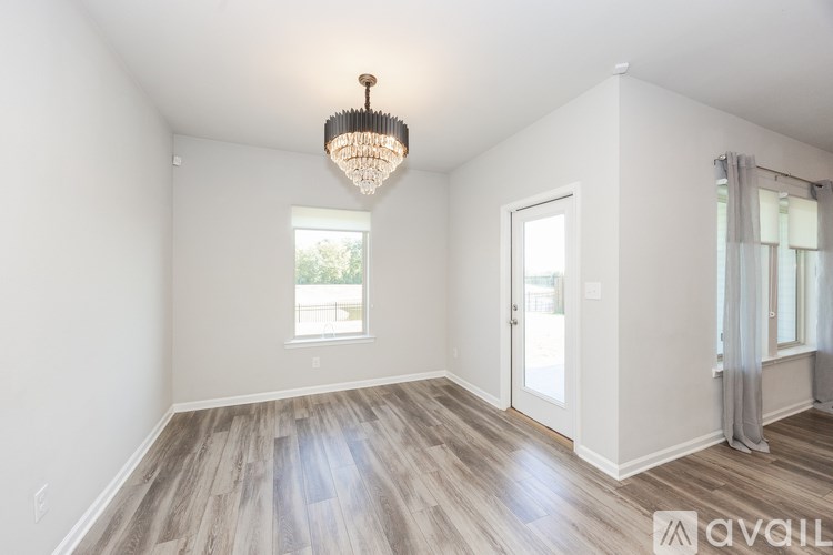 A room with a wooden floor and a chandelier hanging from the ceiling.