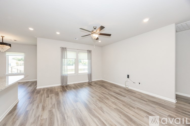 A spacious room with a ceiling fan and lighting fixture.