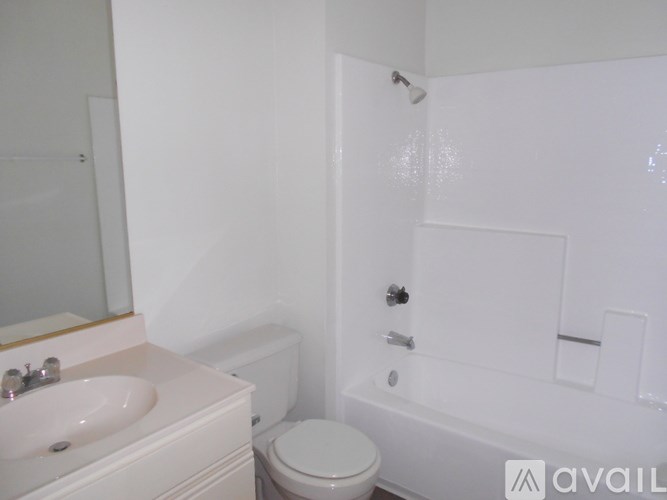 A white bathroom with a toilet, sink, and bathtub.