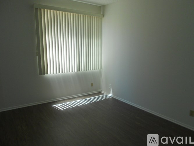 A room with a window covered by horizontal blinds.