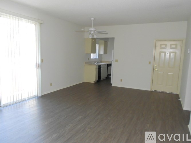 A room with a wooden floor and a ceiling fan.