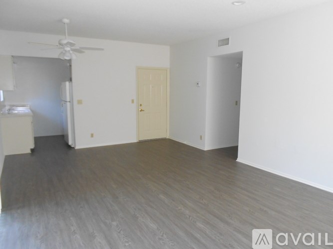 A room with a wooden floor and a ceiling fan.