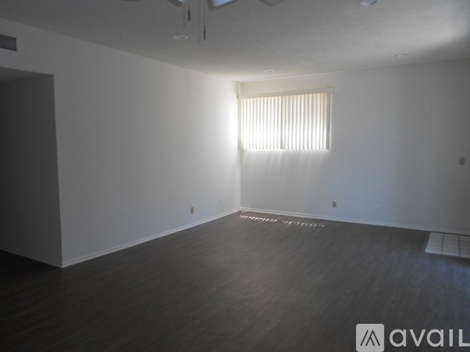 A room with a window and wooden flooring.