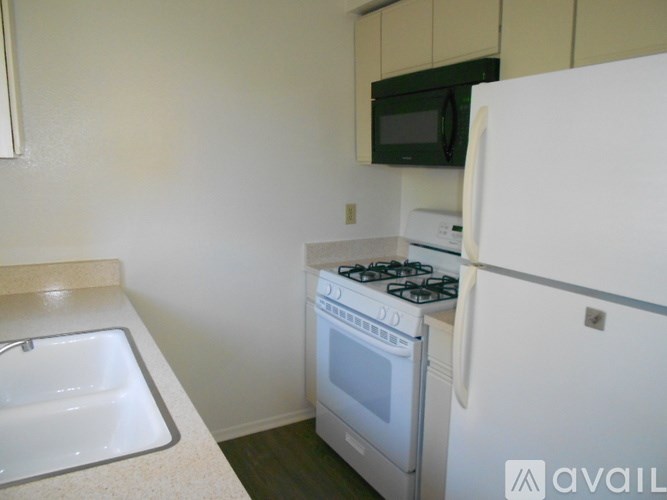A kitchen with a white fridge, stove, and oven.
