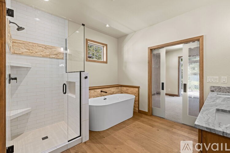 A bathroom with a white tub and a walk-in shower.