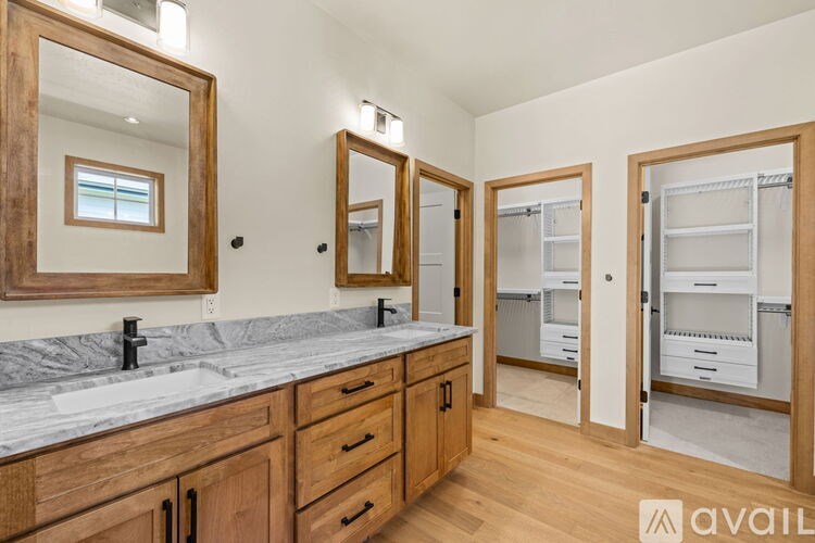 A bathroom with a marble countertop and wooden cabinets.