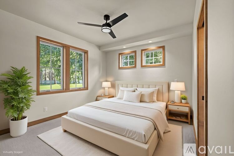 A bedroom with a large bed and a ceiling fan.
