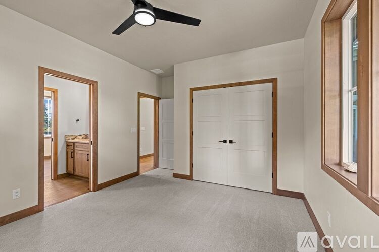 A spacious room with a ceiling fan and a large white closet.