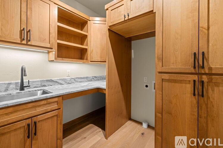 A kitchen with wooden cabinets and a marble countertop.