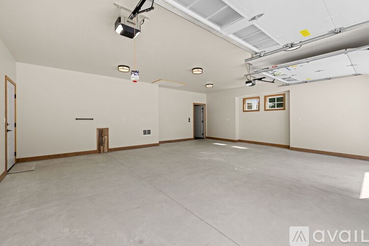 A large empty room with a concrete floor and white walls.