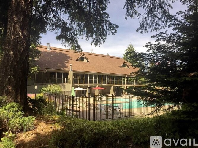 A house with a brown roof and a pool in the backyard.