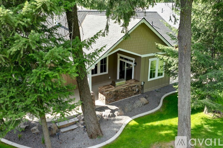 A house with a green roof and a small garden in front.