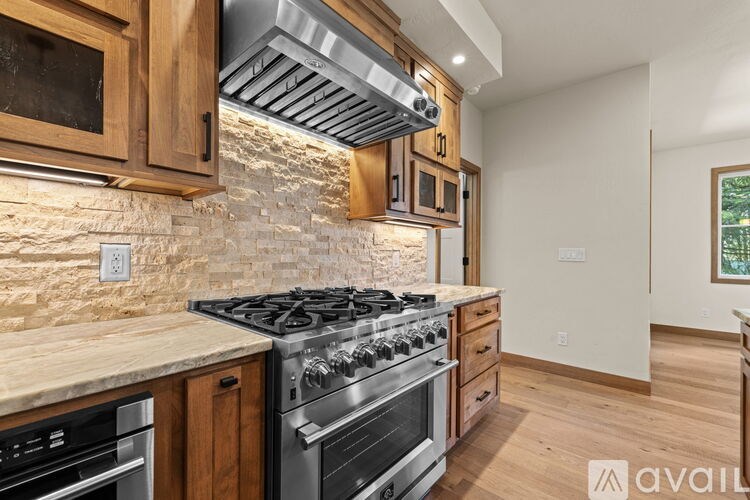 A kitchen with wooden cabinets and a stone backsplash.
