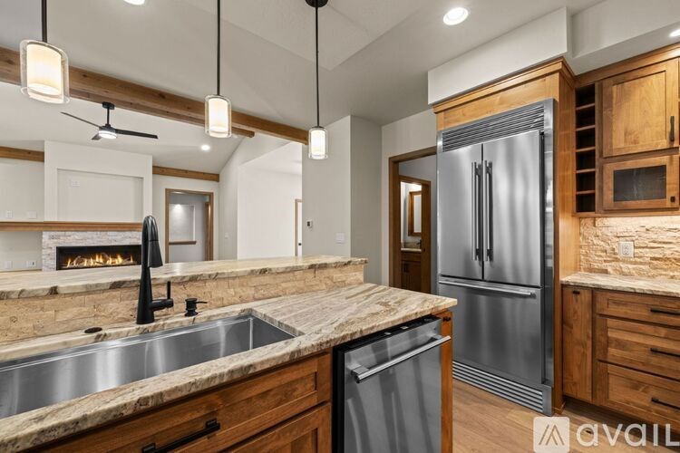 A kitchen with wooden cabinets and a marble countertop.
