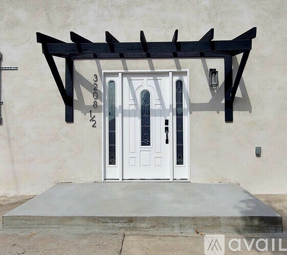 A white door with a black canopy above it.