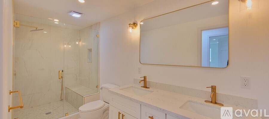 A bathroom with a toilet, sink, and shower.