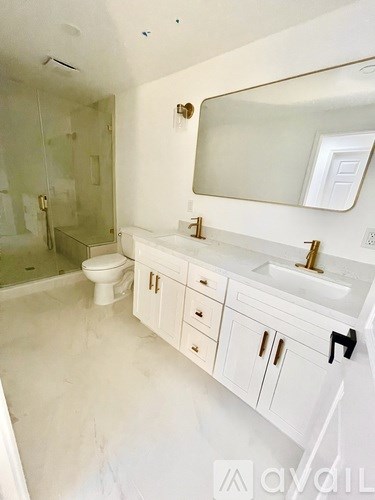 A white bathroom with a sink, toilet and mirror.