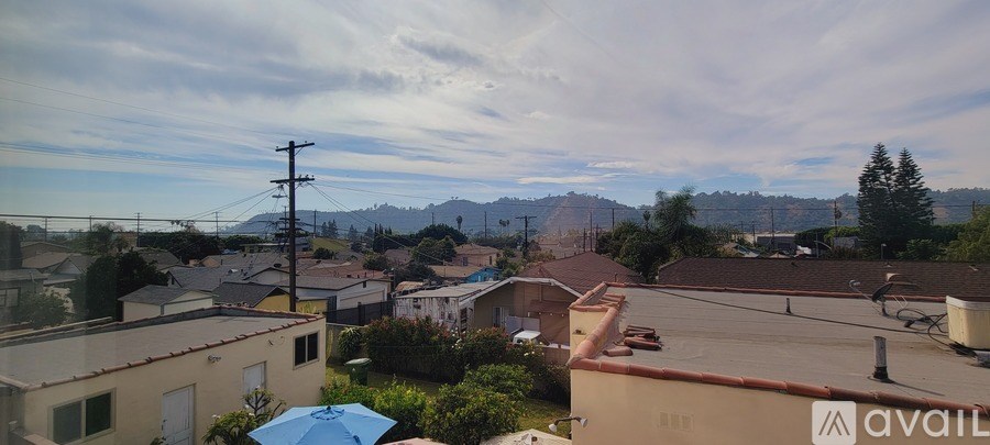 A view of a residential area with houses and a mountain in the distance.