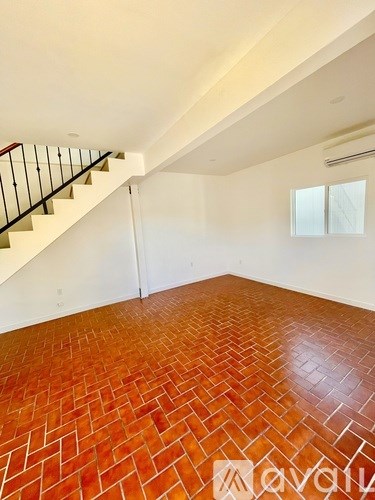 A room with a staircase and a tiled floor.