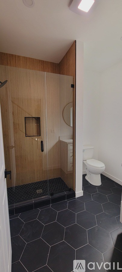 A bathroom with a wooden shower stall and a white toilet.