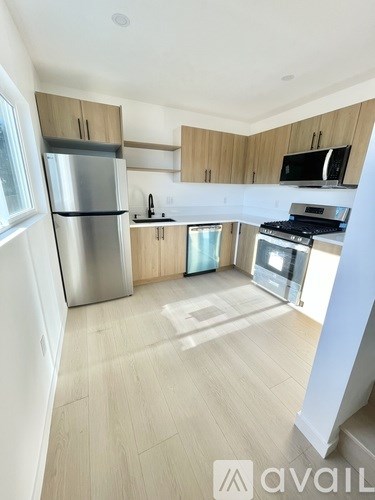 A kitchen with wooden cabinets and a stainless steel refrigerator.