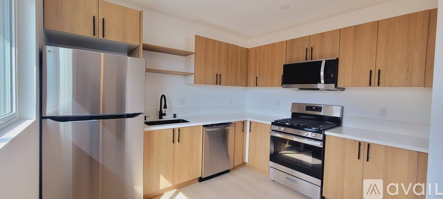 A kitchen with wooden cabinets and a stainless steel refrigerator.