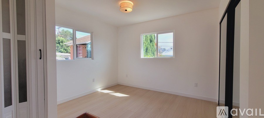 A room with a window and a door is available for rent.