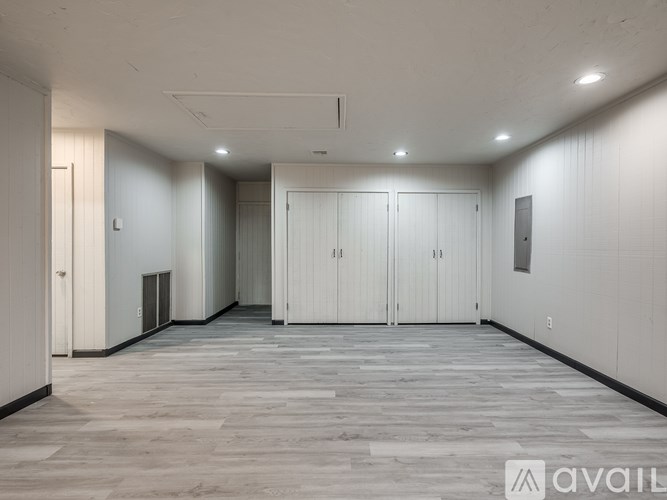 A spacious room with white walls and a grey floor.