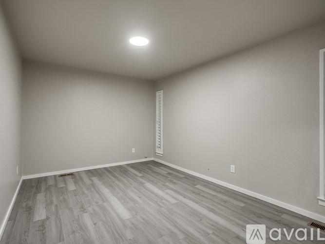 A room with wooden flooring and white walls.