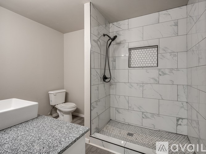 A bathroom with a toilet, sink, and shower.