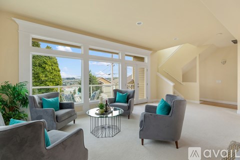 A living room with grey couches and a glass table.