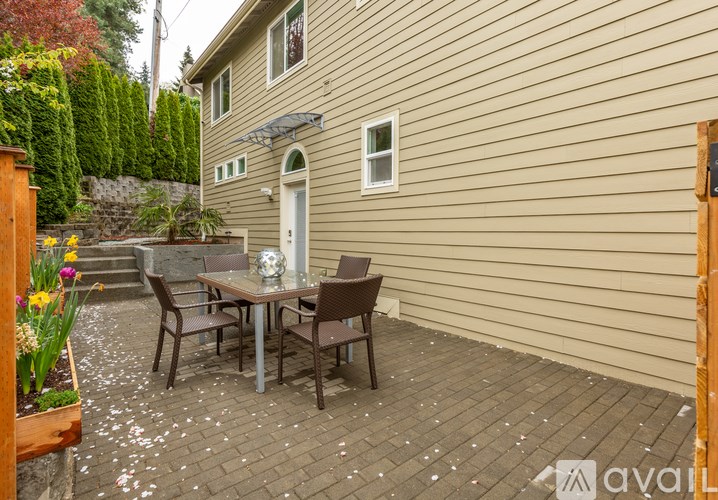 A patio with a table and chairs is in front of a house.