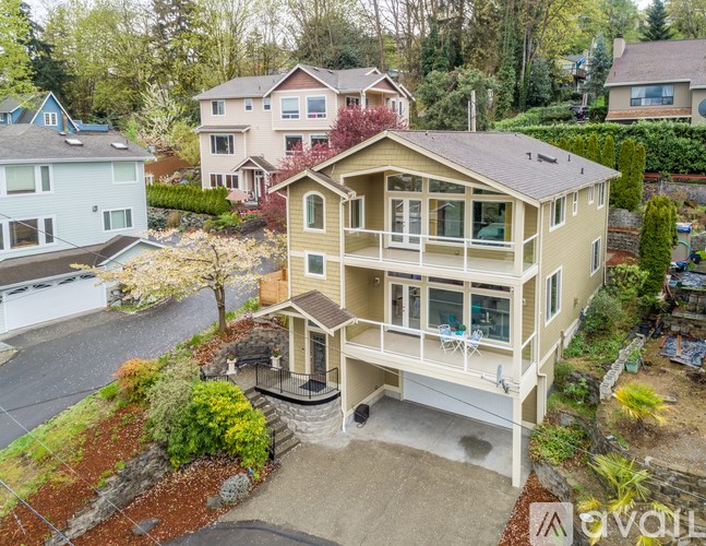 A house with a balcony and a driveway in front of it.