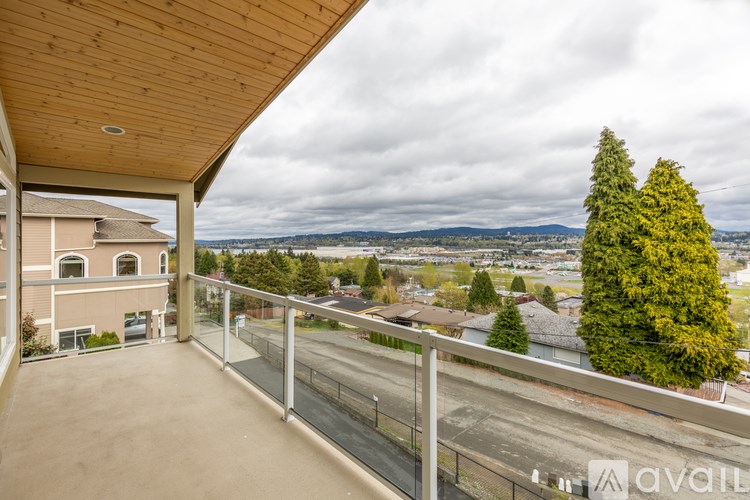 A balcony with a view of a road and houses.