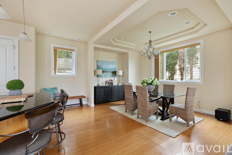 A modern dining room with a glass table and chairs.