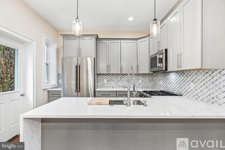 A kitchen with a white countertop and stainless steel appliances.