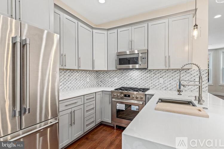A modern kitchen with a stainless steel refrigerator and white countertops.