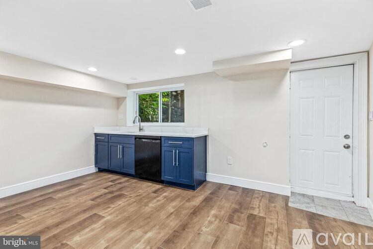 A kitchen with a white door and a window.