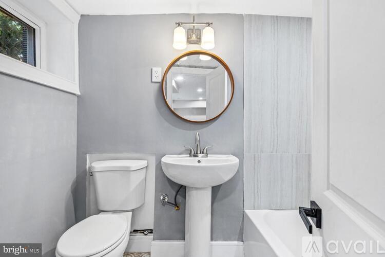 A bathroom with a toilet, sink, and mirror.