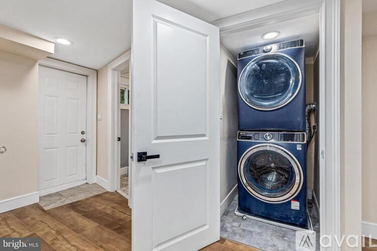 A washing machine is in a doorway between two rooms.