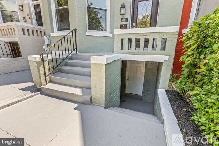 A house with a grey staircase and a white door.