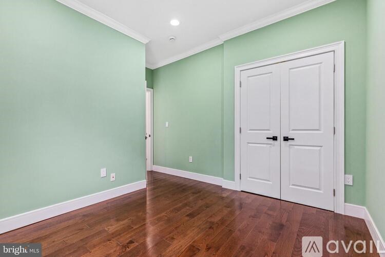 A room with a white door and a green wall.