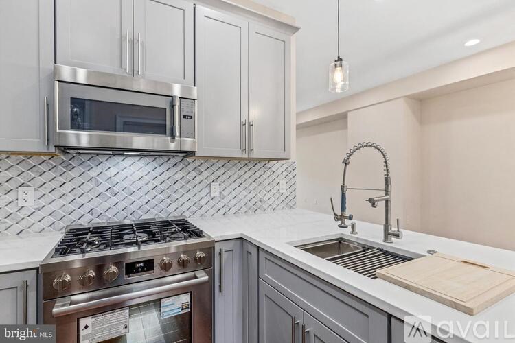 A kitchen with a stove top oven and a microwave above it.
