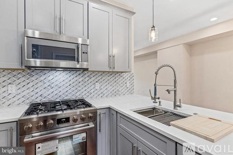 A kitchen with a stove top oven and a microwave above it.