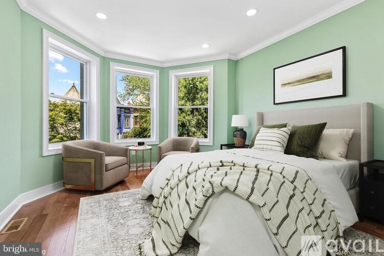 A bedroom with a large bed and a window overlooking a garden.