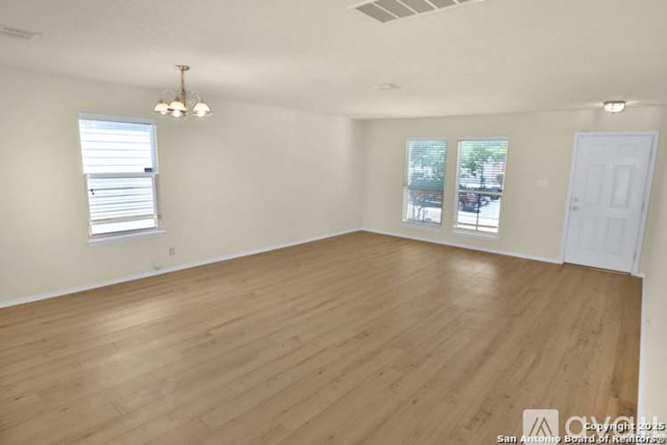 Empty room with wooden flooring and white walls.