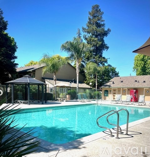 A pool surrounded by trees and a pavilion.