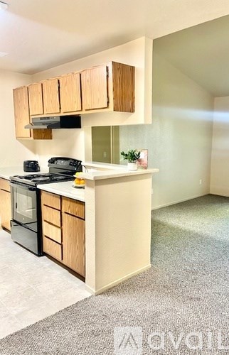 A kitchen with wooden cabinets and a black stove top oven.